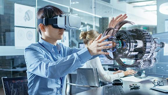 Man wearing virtual reality goggles and working on an a part in a lab